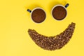 Happy emoticon made of coffee beans on a yellow background. Royalty Free Stock Photo