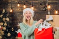 Happy emotion. Euphoria. Crazy comical face. Smiling woman decorating Christmas tree at home. December surprise and Royalty Free Stock Photo