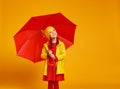 Happy emotional cheerful child girl laughing with red umbrella on yellow background