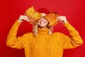 Happy emotional cheerful girl laughing  with knitted autumn   cap and yellow sweater on colored red background Royalty Free Stock Photo