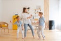 Happy emotional dance of mother with her two children, active modern family