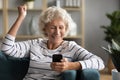 Happy emotional older caucasian woman celebrating online success.