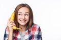 Happy emotional teen girl holding banana like a phone