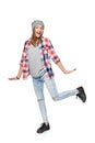 Happy emotional teen girl wearing casual plaid shirt and beanie hat, jumping looking to side surprised Royalty Free Stock Photo