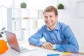 Pleasant man smiling and sitting opposite the laptop Royalty Free Stock Photo