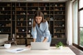 Happy employee girl using laptop, standing at desk with computer Royalty Free Stock Photo
