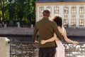 Happy enamored tender couple hugging on the river bank in the city. Romantic engagement of young beautiful people