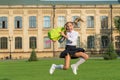 Happy energetic child in formal uniform hold school bag jumping in scholyard, schooling