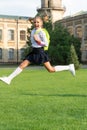 Happy energetic child in uniform with school bag jumping for joy, back to school Royalty Free Stock Photo