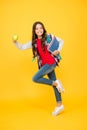 Happy energetic kid run to school holding books and apple natural vitamin yellow background, energy