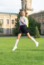 Happy energetic kid in uniform with school bag jumping for joy, back to school Royalty Free Stock Photo