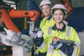 happy engineer team portrait thumbs up enjoy working together in modern metal factory with robotic arm