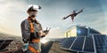 Happy engineer using drone and vr helmet for cheking solar station. in roof Royalty Free Stock Photo