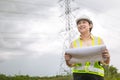 Happy engineer woman happy smiling with high voltages electricity transmission pole building project on background Royalty Free Stock Photo