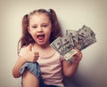 Happy enjoying kid girl holding money and showing thumb up sign. Royalty Free Stock Photo