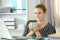 Happy entrepreneur holding a cup of coffee at home office