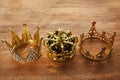 Happy Epiphany day. Three gold crowns on wooden background, symbol of Tres Reyes Magos, Three Wise Men.