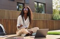 Happy African young woman student elearning using laptop, candid shot. Royalty Free Stock Photo