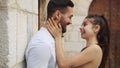 Happy ethnic couple embracing and kissing on street