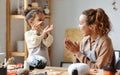 Smiling african american mother and child girl paint  Halloween pumpkins while sitting in cozy kitchen Royalty Free Stock Photo