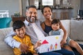 Happy ethnic family showing painting with new home