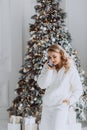 happy european businesswoman talking on mobile phone with client at workplace with decorated Christmas tree behind, smiling woman Royalty Free Stock Photo