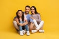 Happy european family of three sitting on floor and embracing