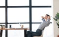 Happy european girl leaning on chair at workplace side view Royalty Free Stock Photo