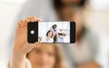 Happy european old, mature and teenage women make photo on smartphone screen in white living room Royalty Free Stock Photo