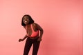 Happy excited afro american girl in sportswear smiling and looking at the camera, isolated over pink background Royalty Free Stock Photo