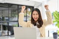 Happy and excited Asian businesswoman looking at laptop screen, screaming with happiness Royalty Free Stock Photo