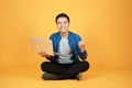 Happy excited Asian man holding laptop and raising his arm up to celebrate success or achievement Royalty Free Stock Photo