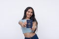 A happy and excited asian trans woman showing off acquired American passport. Isolated on a white background