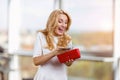 Happy excited blonde caucasian woman withdraws cash money from the red wallet. Royalty Free Stock Photo