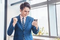 Happy excited business man looking at his smartphone in office Royalty Free Stock Photo