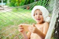 Happy excited child lying in hammok at Christmas family vacations. Boy in Santa hat using mobile phone for buying xmas gifts. Royalty Free Stock Photo