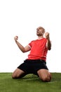 Happy and excited football player in red jersey celebrating scoring goal kneeling on grass pitch Royalty Free Stock Photo