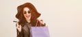 Happy excited hipster woman in sunglasses holding credit card and colorful shopping bags. ?heerful woman looking at camera, isolat