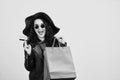 Happy excited hipster woman in sunglasses holding credit card and colorful shopping bags. ?heerful woman looking at camera, isolat Royalty Free Stock Photo