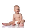 Happy infant child baby boy toddler in diaper is sitting  looking at something near him on copy space on white Royalty Free Stock Photo