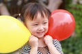 Happy excited joyful girl cute child smile laugh play colorful balloon have fun at summer park nature happiness childhood Royalty Free Stock Photo