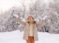 Excited little girl enjoying snow falling on face, playing in snowy forest during first snowfall Royalty Free Stock Photo