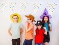 Happy excited kids having fun together at birthday party. Children in funny hats and costumes Royalty Free Stock Photo