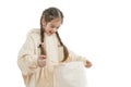 Happy, excited little girl with pigtails dressed in beige hoodie holds shoping package in hands and looking inside Royalty Free Stock Photo