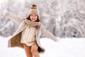 Happy excited little girl playing in winter park, kid running through snow with arms outstretched Royalty Free Stock Photo