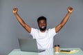 Happy excited man celebrate his success. Winner, black man in office reading on laptop, copy space Royalty Free Stock Photo