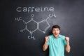 Happy excited man celebrating success over drawn caffeine molecule structure Royalty Free Stock Photo