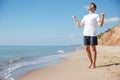 Happy excited man with raised hands celebrating success on beach Royalty Free Stock Photo