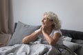 Happy excited mature female tourist waking up in hotel room