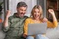 Happy Excited Middle Aged Spouses Celebrating Success With Laptop At Home Royalty Free Stock Photo